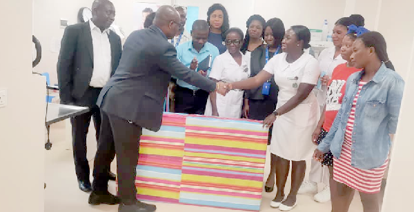 Paul A. Okine (left), Human Resources Manager of Accra East Region of the ECG, presenting the TV to Yvonne Bekoe, Nurse in charge of the Paediatric Ward